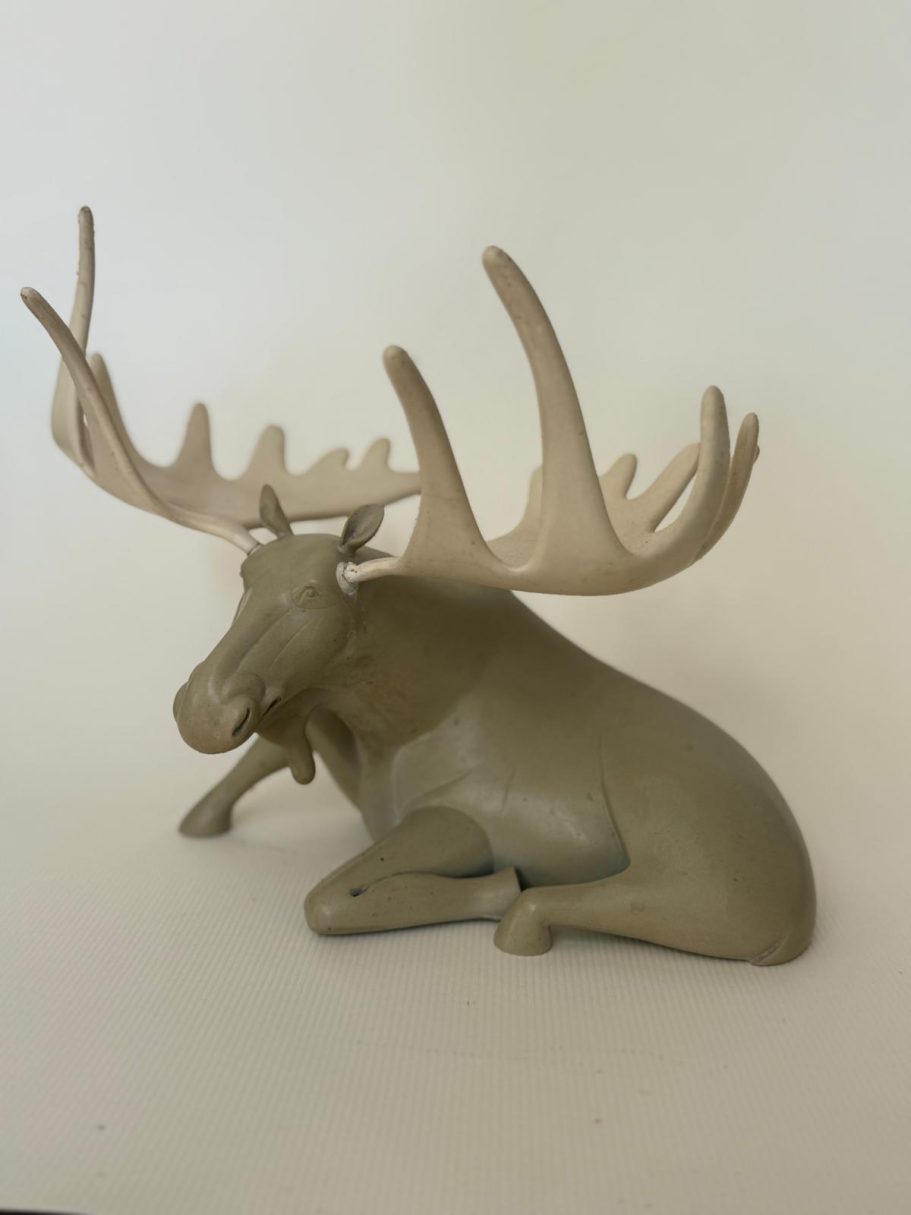Élan en résine de couleur beige, allongé avec des cornes majestueuses.